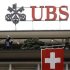 A Switzerland's national flag flies in front of the logo of Swiss bank UBS at the company's headquarters in Zurich