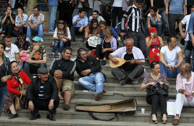 Protesters sit on the steps of Gezi Park of Taksim Square in Istanbul, Saturday, June 15, 2013. Protesters will press on with their sit-in at an Istanbul park, an activist said Saturday, defying government appeals and a warning from Prime Minister Recep Tayyip Erdogan for the two-week standoff that has fanned nationwide demonstrations to end. (AP Photo/Thanassis Stavrakis)
