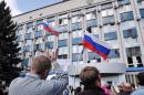 People gather outside the regional Security Service building taken by pro-Russian activists in Lugansk, eastern Ukraine, on April 9, 2014