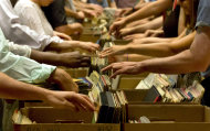 People browse through boxes of records in the New York City Public Library for the Performing Arts at Lincoln Center, Friday, Aug. 9, 2013. The library is selling 22,000 duplicate vinyl records that were preserved in mint condition to raise money for the expansion of the library. (AP Photo/Richard Drew)