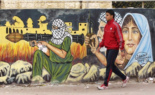 Gaza runner al-Farra walks past a mural in Gaza
