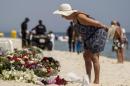 A tourist reads messages left at a makeshift memorial at the beach near the Imperial Marhaba resort, which was attacked by a gunman in Sousse