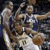Memphis Grizzlies' Mike Conley (11) drives under Utah Jazz's Mo Williams (5) and Paul Millsap, left, during the first half of an NBA basketball game in Memphis, Tenn., Wednesday, April 17, 2013. (AP Photo/Danny Johnston)