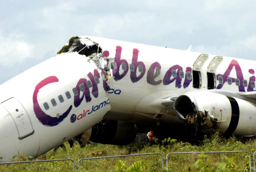 The broken fuselage of a Caribbean Airlines' Boeing 737-800 is seen after it crashed at the end of the runway at Cheddi Jagan International Airport in Timehri, Guyana, Saturday, July 30, 2011. The Caribbean Airlines flight 523 from New York touched down on the rainy runway, slid through a chain-link fence and broke apart just short of a ravine but there were no immediate reports of death among the 163 people aboard, despite several dozen of injuries. (AP Photo/Jules Gibson)