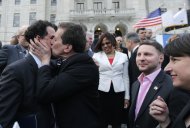 El legislador demócrata Frank Ferri besa a Gordon Fox, líder de la Cámara de Representantes de Rhode Island, después de que fuera promulgada la ley que permite los matrimonios homosexuales en el estado, en Providence, Rhode Island, el 2 de mayo de 2013. (Foto AP/Charles Krupa)