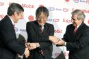 Sherman Glass, presidente de ExxonMobil Refining, a la derecha, y Philippe Ducom, gerente regional de ExxonMobil Japan Group, a la izquierda, dan la mano a Jun Mutoh, director de TonenGeneral Sekiyu K.K., durante una conferencia de prensa en Tokio, el lunes 30 de enero de 2012. Exxon Mobil venderá su negocio de refinería y mercadotecnia a su socia japonesa por 3.900 millones de dólares. (Foto AP/Koji Sasahara)