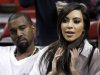 FILE - Kim Kardashian, right, and Kanye West, left, are shown before an NBA basketball game between the Miami Heat and the New York Knicks in this Dec, 6, 2012 file photo taken in Miami. The rapper Kanye West announced at a concert Sunday night Dec. 30, 2012 that his girlfriend is pregnant. He told the crowd of more than 5,000 at the Ovation Hall at the Revel Resort in song form: "Now you having my baby." ( AP Photo/Alan Diaz, File)