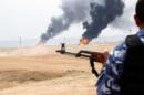 A member of the Kurdish security forces stands guard after explosions at two oil wells in Khabbaz oilfield, 20 km (12 miles) southwest of Kirkuk