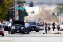 Investigators look at the vehicle involved in a shootout between police and two suspects in San Bernardino, California on December 3, 2015
