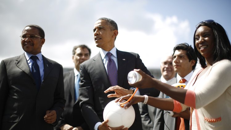 U.S. President Obama holds a soccer ball with a light plugged into it alongside Tanzania's President Kikwete during a demonstration at the Ubungo Power Plant in Dar es Salaam