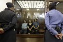 FILE - In this Aug. 17, 2012 file photo, feminist punk group Pussy Riot members, from left, Yekaterina Samutsevich, Maria Alekhina and Nadezhda Tolokonnikova sit in a glass cage at a court room in Moscow, Russia. Jailed Pussy Riot member Nadezhda Tolokonnikova said in an interview released by Germany's Der Spiegel magazine on Sunday, Sept. 2, 2012 that she regrets nothing about the band's anti-government performance in a cathedral that got them convicted of hooliganism and sentenced to two years behind bars. (AP Photo/Sergey Ponomarev, File)