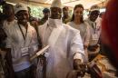 Incumbent Gambian president Yahya Jammeh (C) has his finger inked before casting his marble in Banjul on December 1, 2016