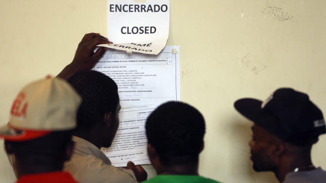 In this Jan. 13, 2015 photo, migrants, most of them from Haiti, look at job postings at Our Lady of Peace Catholic Church which helps recently arrived migrants find work in Sao Paulo, Brazil. There are fewer jobs in Brazil than there are Haitians looking for work. An open-door policy intended to help migrants from the impoverished island is fueling Brazil’s largest immigration wave since World War II and prompting calls for lawmakers to do more to help the new arrivals. (AP Photo/Andre Penner)