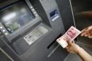 A woman takes money out of an automatic teller machine in Chengdu on May 21, 2007
