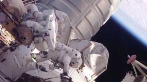 NASA astronauts work to move a stalled robotic transporter on International Space Station in this still image from NASA TV