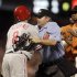 Philadelphia Phillies' Shane Victorino, left, is restrained by home plate umpire Mike Muchlinski, after Victorino was hit by a pitch thrown by San Francisco Giants' Ramon Ramirez, right, during the inning of a baseball game Friday, Aug. 5, 2011, in San Francisco. The altercation caused a benches clearing brawl. (AP Photo/Ben Margot)