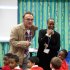 In this image made available  by LOCOG shows Oscar winning director Danny Boyle as he visits  Colegrave Primary School, Newham London  a school selected to audition for the London 2012 Opening Ceremony, Friday Jan. 27, 2012. Boyle offered a sneak peek Friday of his vision for the 2012 London Olympics opening ceremony, revealing that he would ring a massive bell to start the festivities and include a segment on one of Britain's most maligned institutions, the National Health Service. (AP Photo/ Dave Poultney/LOCOG)