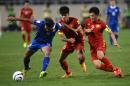 Thailand's Mongkol (left) holds off two Vietnamese players during a World Cup 2018 qualifier at My Dinh stadium in Hanoi, on October 13, 2015. Thailand defeated Vietnam 3-0