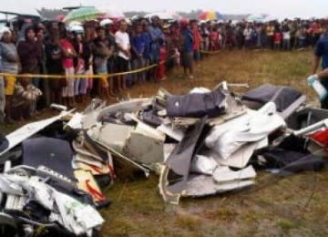 Sejumlah warga menyaksikan bagian bangkai pesawat Merpati MA-60 PK yang hancur setelah jatuh sekitar 500 m sebelum mendarat di Bandara Kaimana, Papua Barat, Ahad (8/5).
