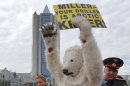A police officer detains s Greenpeace activist dressed as a polar bear outside Gazprom's headquarters in Moscow, Russia, Wednesday, Sept. 5, 2012. Russian and international environmentalists are protesting against Gazprom's plans to pioneer oil drilling in the Arctic. (AP Photo/Misha Japaridze)