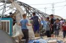 Displaced people inspect tents that were destroyed by fire at Yahayawa refugee camp near Kirkuk, Iraq