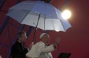 Side lit by a stage light Pope Francis addresses the youth gathered at the World Youth Day Welcome Feast on the Copacabana beachfront in Rio de Janeiro, Brazil, Thursday, July 25, 2013. Francis addressed the young pilgrims from 175 nations gathered on the famous beach. Francis is on the fourth day of his trip to Brazil. Holding the umbrella is Vatican Master of Ceremonies, Mons. Guido Marini. (AP Photo/Stefano Rellandini, Pool)