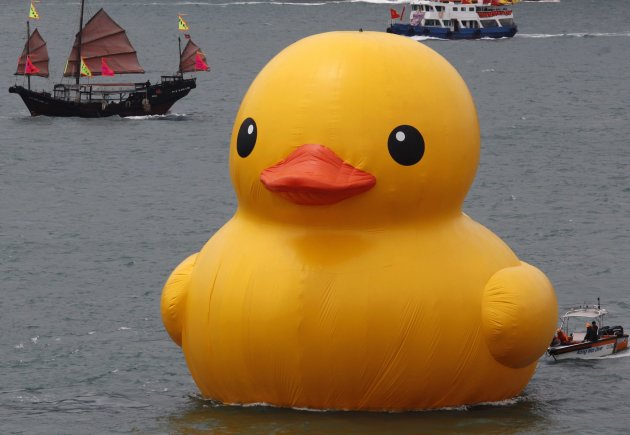 Tourist junk sails past Rubber Duck by Dutch artist Hofman at Hong Kong's Victoria Harbour