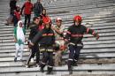 Emergency personnel carry an injured supporter at the Mohammed V Stadium in Casablanca following clashes between rival fans of Raja de Casablanca after their match against Chabab Rif Al Hoceima on March 19, 2016