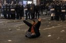 A protestor sits in front of the riot police riot to stop the clashes during a general strike in Madrid, Spain, Wednesday, Nov. 14, 2012. Spain's main trade unions stage a general strike, coinciding with similar work stoppages in Portugal and Greece, to protest government-imposed austerity measures and labor reforms. The strike is the second in Spain this year. (AP Photo/Andres Kudacki)