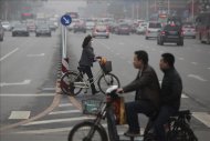 Una pareja se protege de la polución con máscaras, cerca de la plaza de Tiananmen, en Pekín. EFEPeatones circulan por las calles contaminadas de Shenyang en China. EFE/Archivo