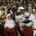 Oklahoma infielder Lauren Chamberlain, in center with batting helmet, is mobbed by her teammates following her 12th inning home run against Tennessee in the first game of the best of three Women's College World Series NCAA softball championship series in Oklahoma City, Monday, June 3, 2013. Oklahoma won 5-3 in 12 innings.(AP Photo/Sue Ogrocki)