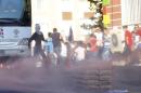Demonstrators run away from tear gas used by riot police to disperse them during a march in solidarity with Kurdistan Workers Party jailed leader Abdullah Ocalan in Diyarbakir