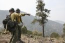 Crew members from the Granite Mountain Hotshots of Prescott, Ariz., cut a fire line along a mountain ridge outside Mogollon, N.M., Saturday, June 2, 2012, in an effort to manage and contain the Whitewater-Baldy fire which has burned more than 354 square miles of the Gila National Forest in New Mexico. Unlike last year's megafires in New Mexico and Arizona, this blaze is burning in territory that has been frequently blackened under the watchful eye of the Gila's fire managers. (AP Photo/U.S. Forest Service, Tara Ross)
