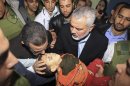 Gaza's Hamas Prime Minister Ismail Haniyeh, right, and Egyptian Prime Minister Hesham Kandil, left, hold the body of a Palestinian boy they claim was killed in an Israeli strike on Gaza City, as they show the body to the media at Shifa hospital in Gaza City, Friday, Nov. 16, 2012. Neighbors said the boy was killed in a blast around 8:30 a.m. Friday, around the time Kandil was entering the territory. Israel, which ordinarily confirms strikes, vociferously denied carrying out any form of attack in the area since the previous night. (AP Photo/Mahmud Hams, Pool)