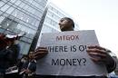 Burges, a self-styled cryptocurrency trader and former software engineer from London, holds a placard to protest against Mt. Gox in Tokyo