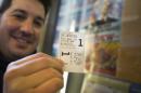 FILE - In this Dec. 25, 2014 file photo, Derek Karpel holds his ticket to a screening of "The Interview" at Cinema Village movie theater, in New York. The film raked in just over $1 million in ticket sales from 331 locations for an impressive $3,142 per theater average, according to distributor Sony Pictures. (AP Photo/John Minchillo, File)