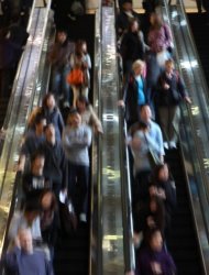 File photo shows people on an escalator in Hong Kong. Younger Hong Kong residents typically live at home deep into their 20s or 30s because they can't afford to marry and move out earlier, meaning that many sleep in close proximity to their parents in cramped apartments