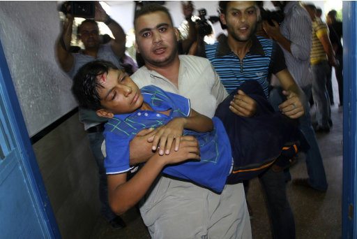 A Palestinian youth, injured during an Israeli airstrike, is carried into Shifa hospital in Gaza City, Sunday, Aug. 21, 2011. Militants in the Hamas-ruled Gaza Strip bombarded southern Israel with rockets and mortars Sunday, striking an empty school and sending thousands of Israelis into bomb shelters, as Israel responded with airstrikes and diplomats scrambled to keep a new convulsion of Israeli-Palestinian violence from escalating. (AP Photo/Ashraf Amra)