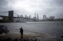 A man watches rising waters on the East River from Brooklyn as Hurricane Sandy made its approach in New York