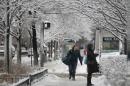 Commuters walk through snow covered sidewalks after an overnight snowstorm Wednesday, March 12, 2014, in downtown Chicago. A late winter storm dumped more than 5 inches of snow in the Chicago area, causing power outages and headaches for commuters. (AP Photo/Kiichiro Sato)