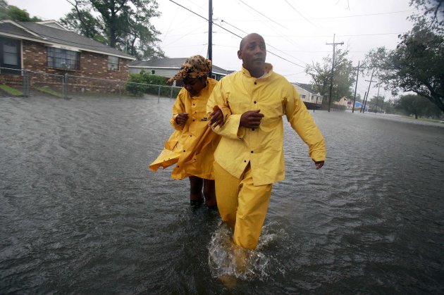 A man and a woman walk through flood waters on St. Roch ave. as Hurricane Isaac makes land fall in New Orleans, Louisiana August 29, 2012. The two were trying to reach a local gas station to retrieve supplies. REUTERS/Sean Gardner (UNITED STATES - Tags: ENVIRONMENT DISASTER)