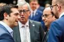 Greek Prime Minister Alexis Tsipras, left, speaks with, from left, European Commission President Jean-Claude Juncker, French President Francois Hollande and Belgian Prime Minister Charles Michel during a meeting of eurozone heads of state at the EU Council building in Brussels on Sunday, July 12, 2015. Skeptical European creditors raced Sunday to narrow differences both among themselves and with Athens, aiming to come up with a tentative agreement to stave off an immediate financial collapse in Greece that would reverberate across the continent. (AP Photo/Geert Vanden Wijngaert)