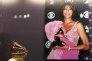 A photograph of the late singer Whitney Houston holding a Grammy Award is displayed next to one of her Grammys during a press preview of the new exhibit at The Grammy Museum in Los Angeles