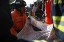 Rescuers carry the body of Cruz Abel De Leon, who died in a landslide triggered by a 7.4-magnitude earthquake, in El Recreo