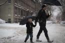 Boy tries to catch snow on his tongue while walking with his father in the Park Slope area of the Brooklyn borough of New York
