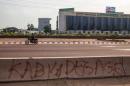 A man drives past a sign asking for President Joseph Kabila's resignation on an avenue in Kinshasa on December 19, 2016