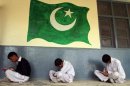 Students sit near an image of Pakistan's national flag at the Musa Neka Public School in Wana, the main town in Pakistan's South Waziristan tribal region bordering Afghanistan