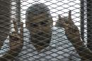 Al-Jazeera news channel's Egyptian-Canadian Mohamed Fahmy inside the defendants cage during his trial for allegedly supporting the Muslim Brotherhood at the police institute near Cairo's Tora prison, on June 23, 2014