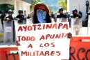 A woman holds a banner reading "Ayotzinapa everything points to the military" during a protest demanding justice in the disappearance of 43 students, on January 12, 2015, at the naval base in Acapulco