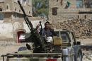 A Houthi Shiite rebel mans a machine gun mounted on a military truck in Sanaa, Yemen, Monday, Oct. 20, 2014. Yemeni security officials said al-Qaida's Sunni militants seized al-Adeen town 200 kilometers (125 miles) south of the capital Sanaa in Ibb province. (AP Photo/Hani Mohammed)